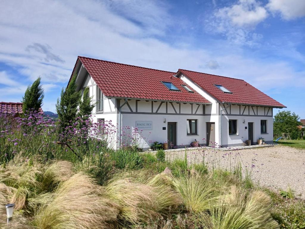 a white house with a red roof at Binzighof Ferienhäuser in Oberkirch