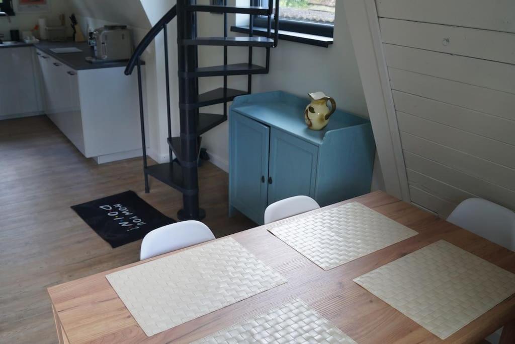 a dining room with a table and a cat sitting on a blue cabinet at Domek nad Jeziorem Kaszuby max 6 os in Bieszkowice