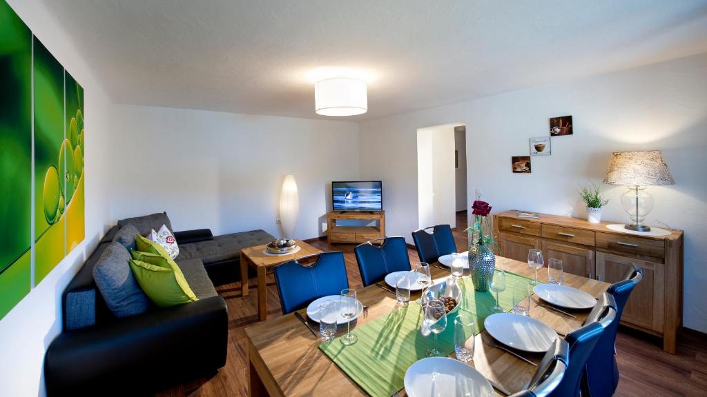 uma sala de estar com uma mesa e cadeiras azuis em Appartementhaus Fritz-Rosenkranz em Mariapfarr