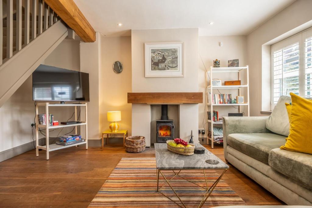 a living room with a couch and a fireplace at Sherbet Cottage in South Creake