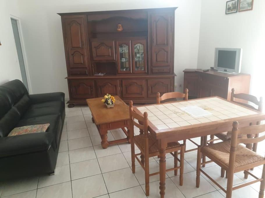 un salon avec une table et un canapé dans l'établissement Appartement près des plages en plein centre ville, à Loupian
