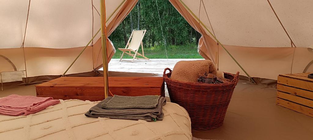 a tent with a bed and baskets in a room at Siedlisko Stasin in Trojanów