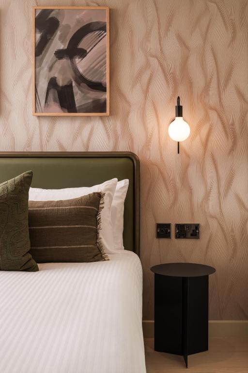 a bedroom with a bed and a lamp and a table at Central Park Hotel in London