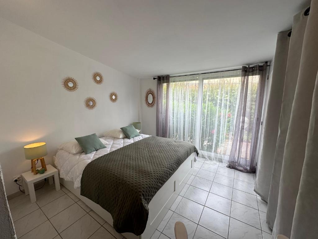 une chambre avec un lit et une grande fenêtre dans l'établissement Maison proche village naturiste - 7 personnes, au Cap d'Agde