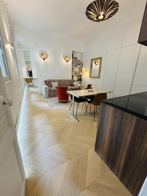 un salon avec une table et une salle à manger dans l'établissement Modern apt Canal st Martin, à Paris