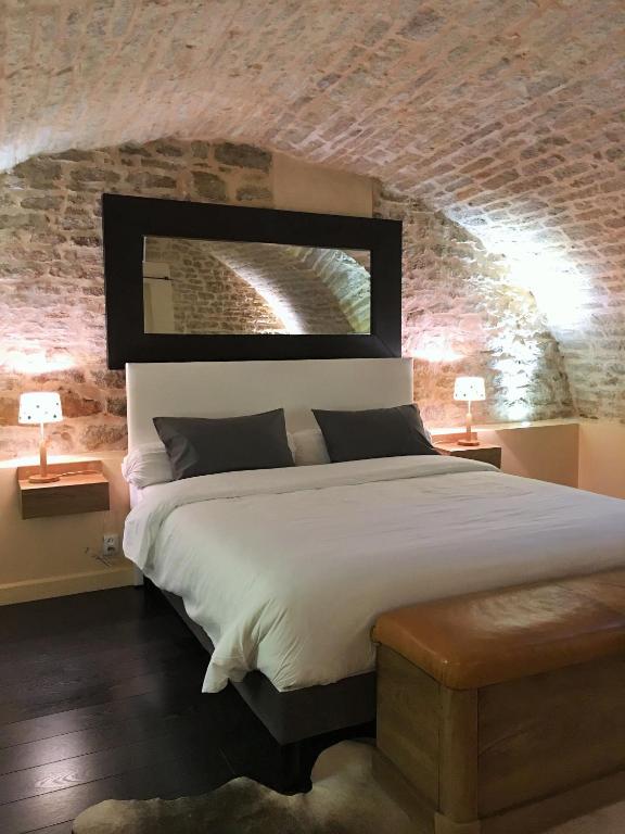 une chambre avec un grand lit avec un mur de briques dans l'établissement Appartement La Borde, à Dijon