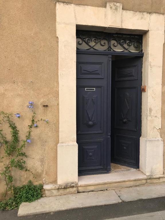 a black door on the side of a building at le Petit in Coursan
