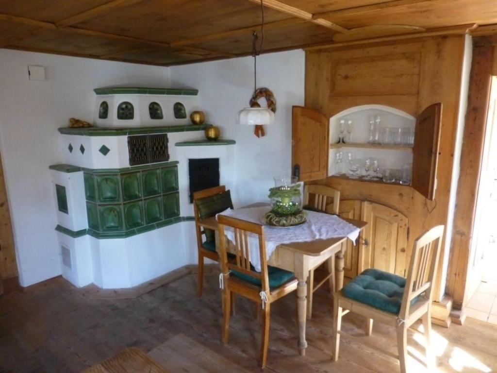 cocina con mesa y estufa verde en Ferienhaus Judie, en Lechbruck