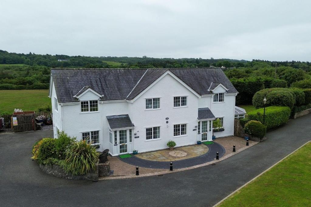 - une vue aérienne sur une maison blanche avec une allée dans l'établissement Sea View, à Moelfre
