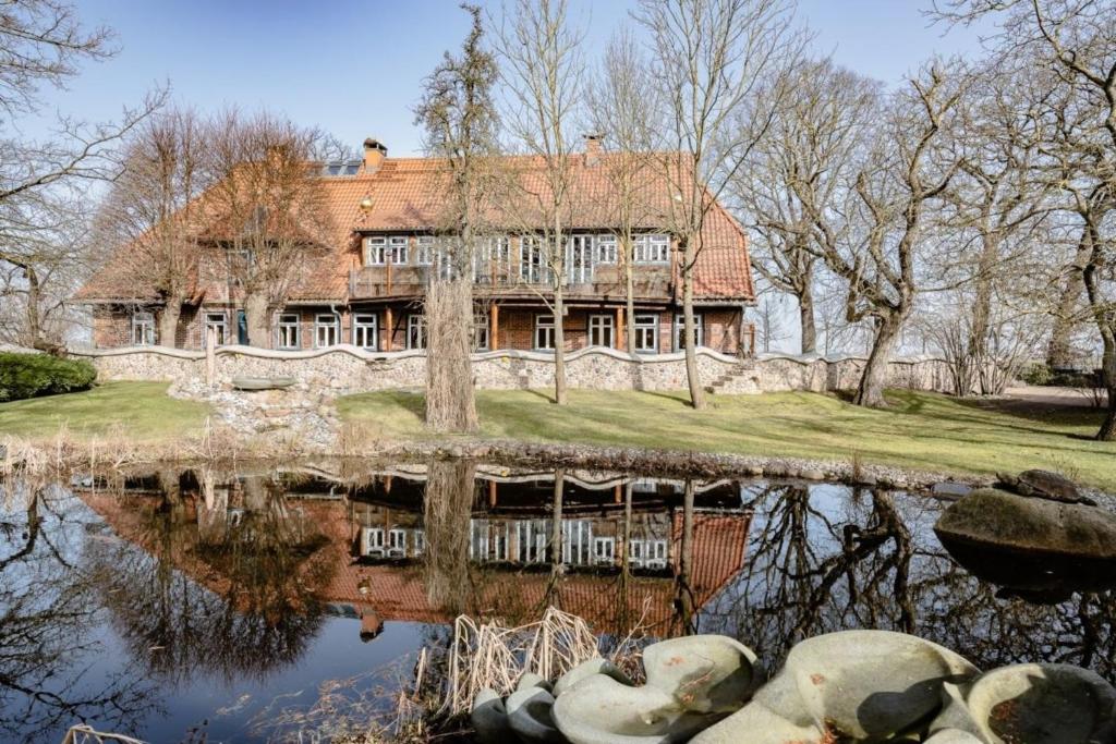 una vecchia casa con un riflesso nell'acqua di natürliches Umfeld für Genießer Wohnung Teichblick a Bleckede