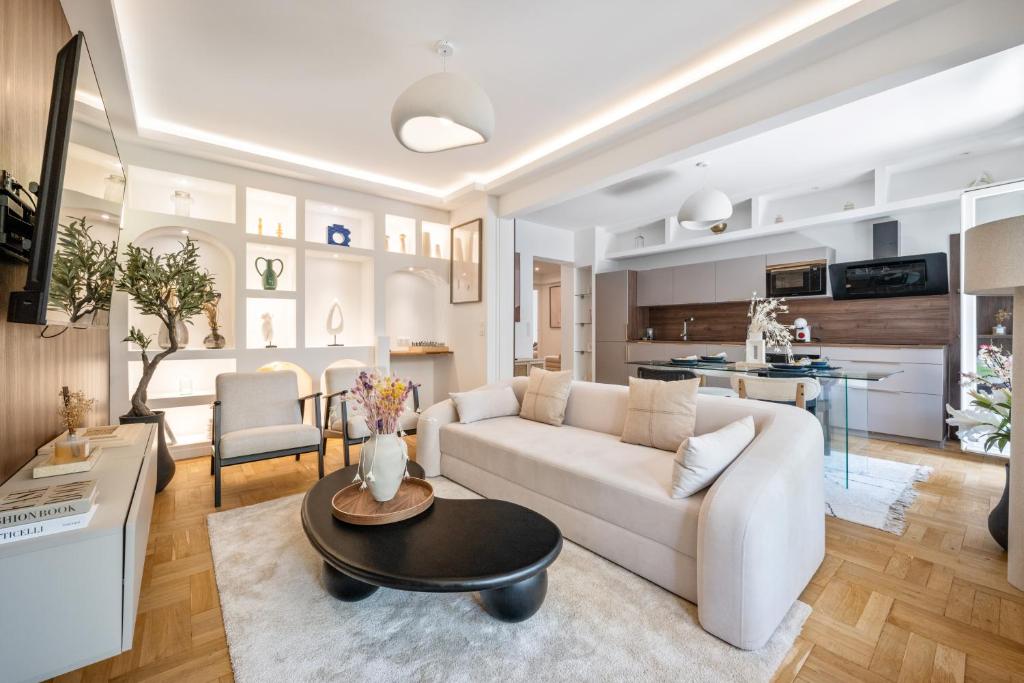 un salon avec un canapé blanc et une table dans l'établissement Luxueux, spacieux et tout équipé à 5 min du port, à Nice