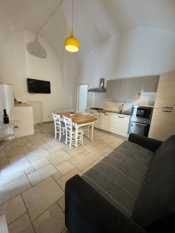Una cocina con una mesa y sillas en una habitación. en Augustus B&B, en Terlizzi