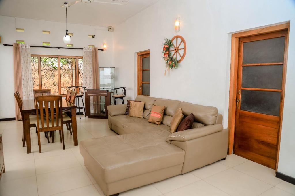 a living room with a couch and a table at Destine Holiday Bungalow in Galle