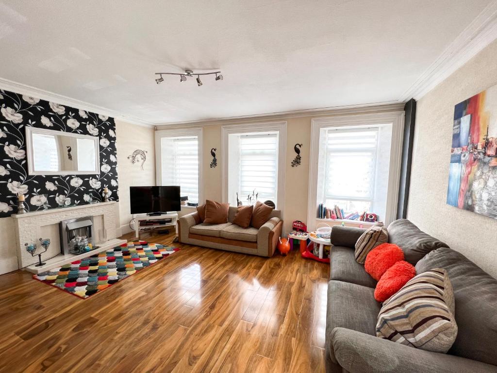 uma sala de estar com um sofá e uma televisão em Station View Portrush em Portrush