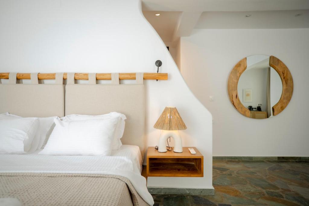 a bedroom with a bed and a table with a lamp at Villa Vivari Suites in Vivari