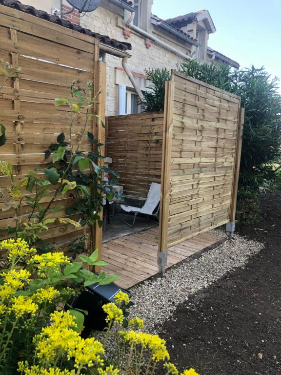 d'un jardin avec une clôture en bois et une chaise. dans l'établissement Villa, à Saint-Germain-de-Lusignan