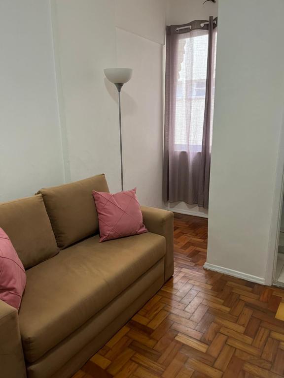 een woonkamer met een bank en een lamp bij Lindo Studio Flamengo in Rio de Janeiro