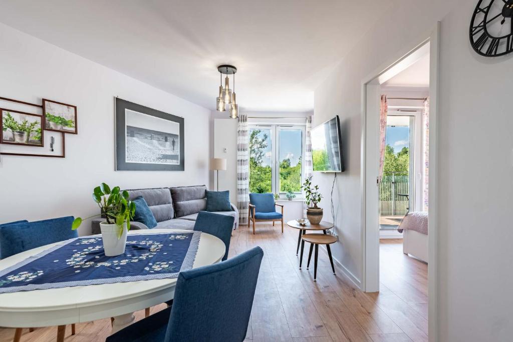 a living room and dining room with a table and a couch at Blue Sun Apartament Słoneczny in Kołobrzeg