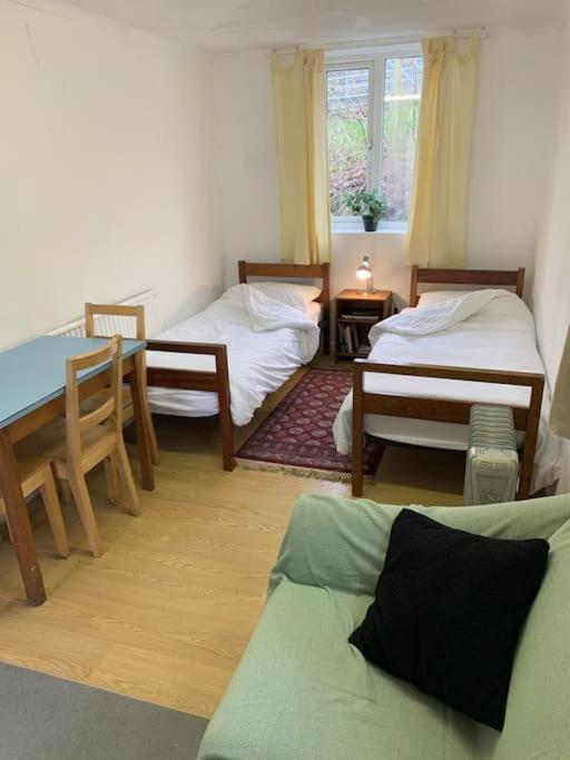 a living room with two beds and a table at Sleeping Giant outdoor adventure flat in Pen-y-cae