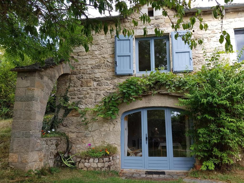 une maison en pierre avec une porte bleue et des fenêtres dans l'établissement Gite pratlong, à Saint-Pierre-des-Tripiers