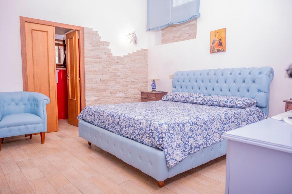 sypialnia z niebieskim łóżkiem i niebieskim krzesłem w obiekcie Dimora Belvedere w Alberobello
