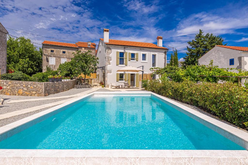 a swimming pool in front of a house at Holiday house Rural home Frane in Kornić