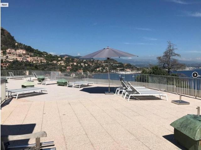 un groupe de bancs assis sur un patio près de l'eau dans l'établissement Apartment in Theoule sur mer village, à Théoule-sur-Mer