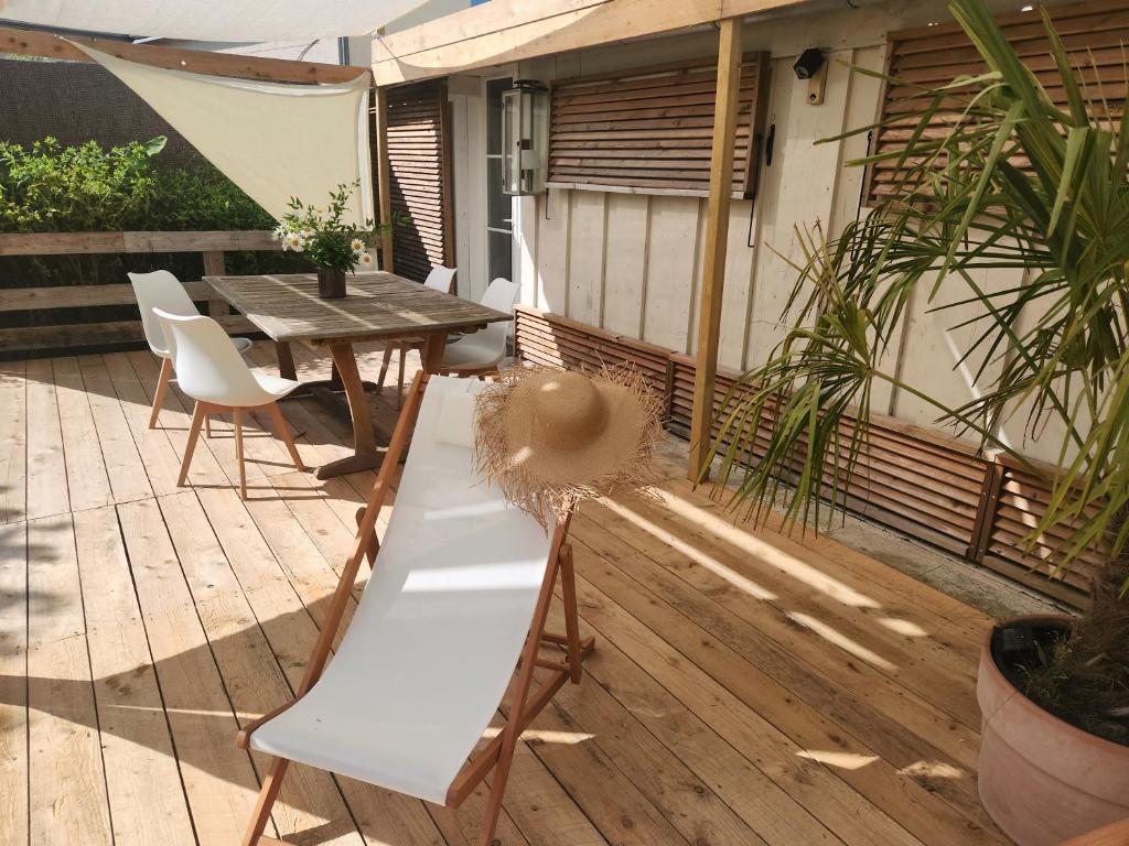 un banc sur une terrasse avec une table et des chaises dans l'établissement L'Annexe du Moulin, à Noyers-sur-Cher