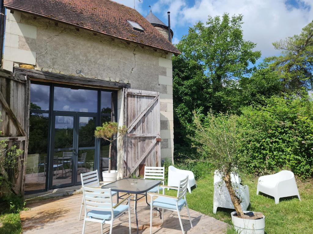eine Terrasse mit Tisch und Stühlen vor einem Haus in der Unterkunft La Grange du Moulin in Noyers-sur-Cher