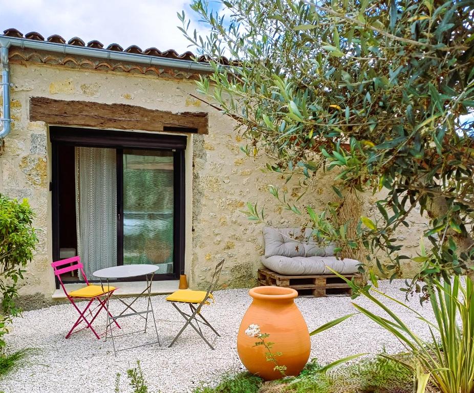 un patio con sillas y un sofá frente a un edificio en Clos Baroanni - Chambre Oléa, en Terraube