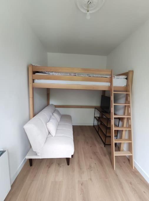 une chambre avec deux lits superposés et un canapé dans l'établissement Bel Appartement avec vue square - Paris Nation - 3 Voyageurs, à Paris
