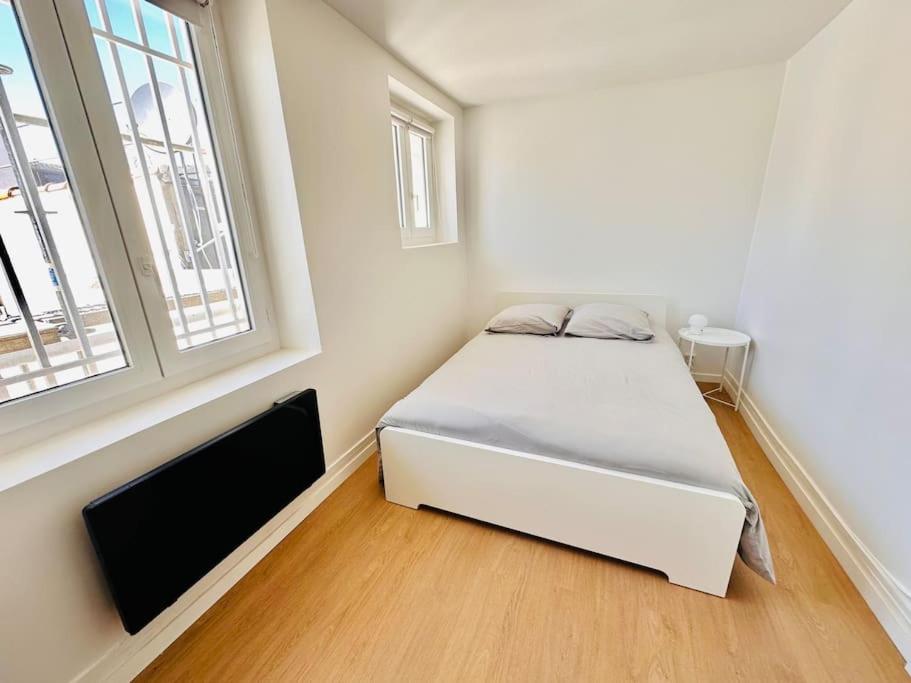 une chambre avec un lit blanc et une fenêtre dans l'établissement Cosy Saint-Denis 2 personnes, à Saint-Denis