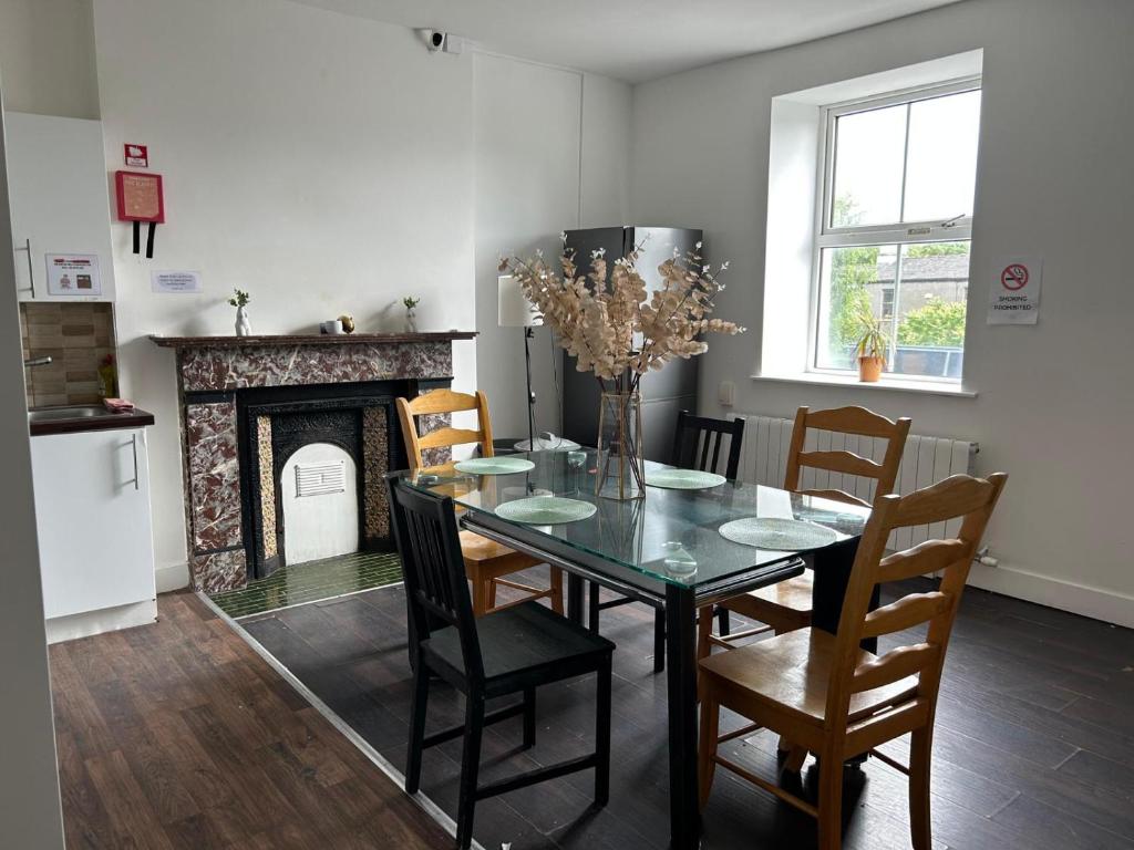a dining room with a table and chairs and a fireplace at Sarsfields Communities in Dolphinʼs Barn
