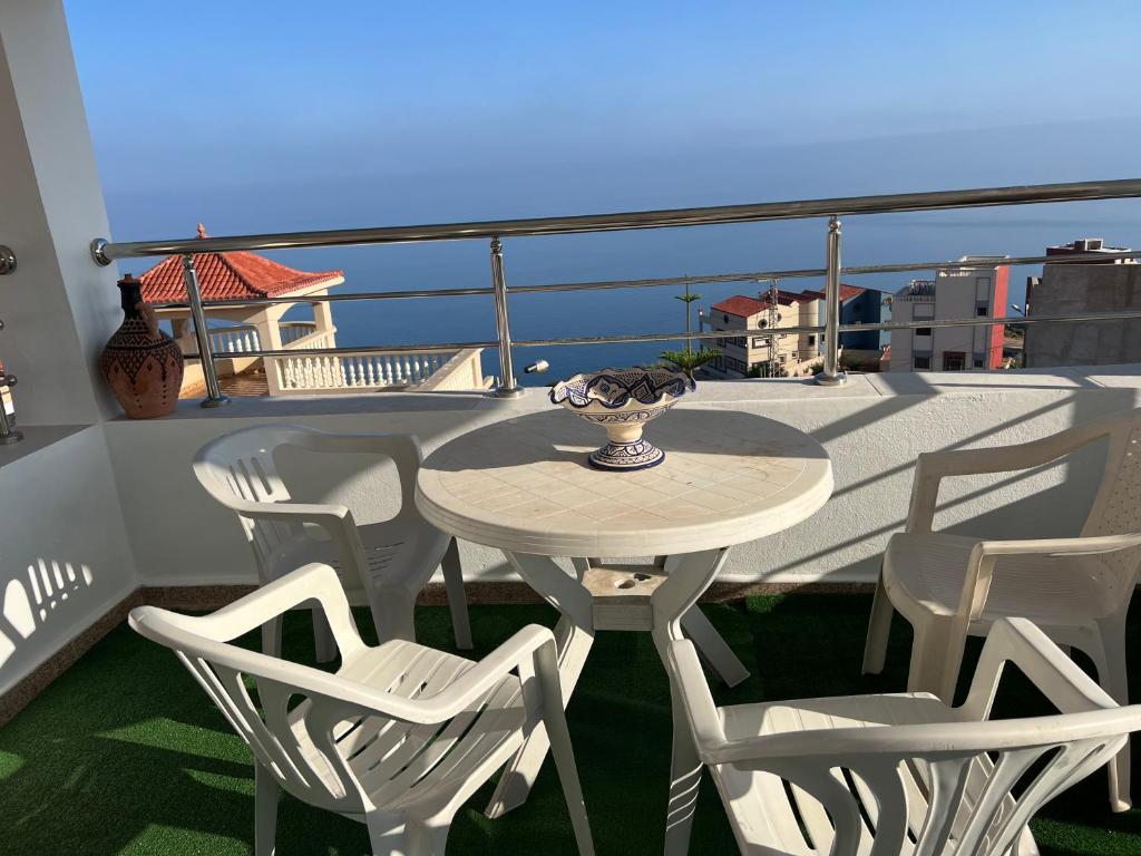 a table and chairs on a balcony with the ocean at Apartamento con vistas al mar 3 in Al Hoceïma