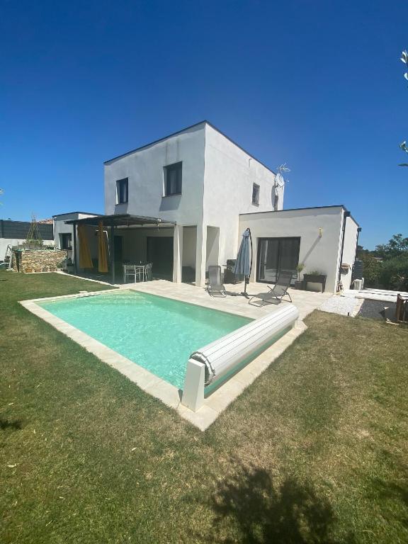 une maison avec une piscine devant une maison dans l'établissement La Bella Vita, à Nîmes
