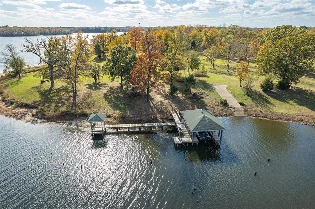 an aerial view of a dock on a lake at Entire lake house at Lake Fork with private bay, boat ramp, fishing light & 8 acres land in Alba
