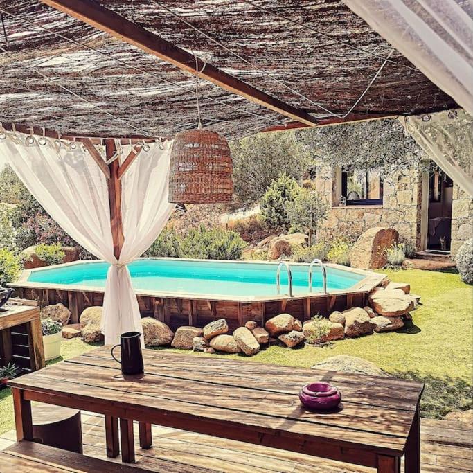 une piscine dans une cour avec une table en bois dans l'établissement Loue petite maison individuelle à Bocca Del oro, à Porto-Vecchio