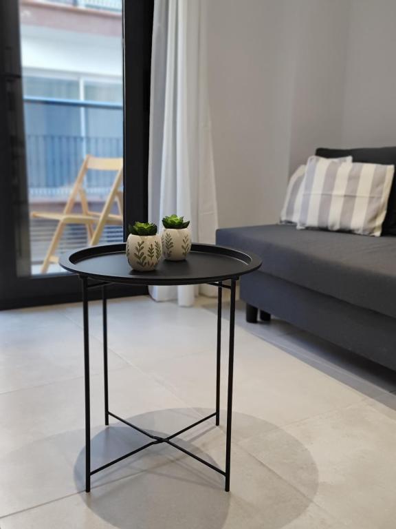 a table with two vases on it in a living room at AM Chinorros Square. in Fuengirola