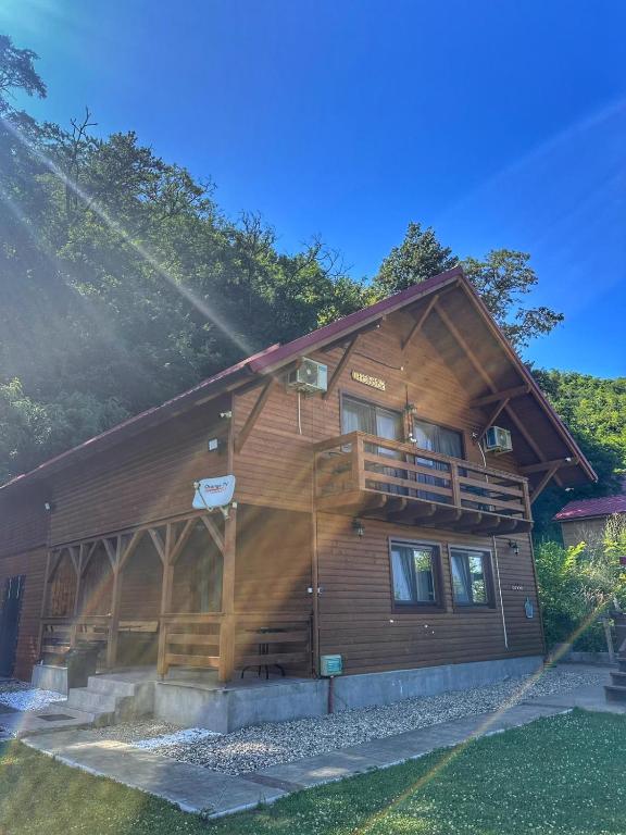a large wooden cabin with a balcony on the side at Casa Favorit in Costeşti