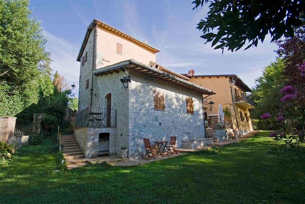 een oud stenen huis in een grasveld bij Casale del Monsignore in Spoleto