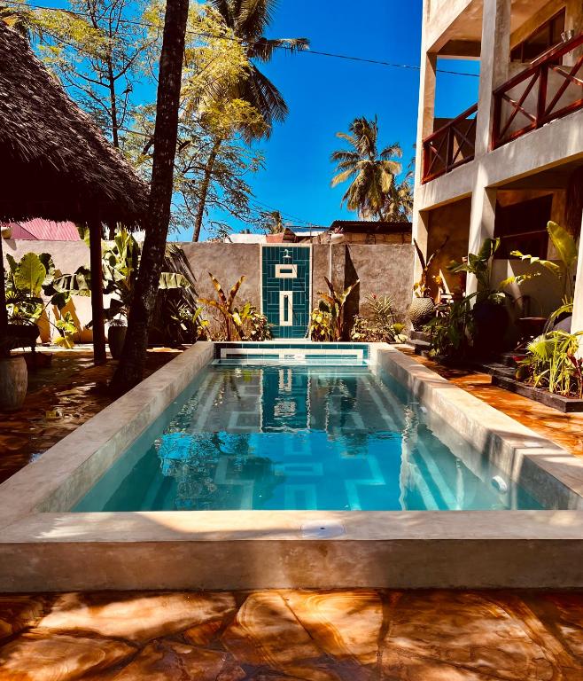 a swimming pool in front of a building at BamBam Bungalows Zanzibar in Nungwi