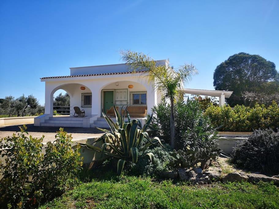 una pequeña casa blanca con una puerta verde en Dolce Villa, en Francavilla Fontana