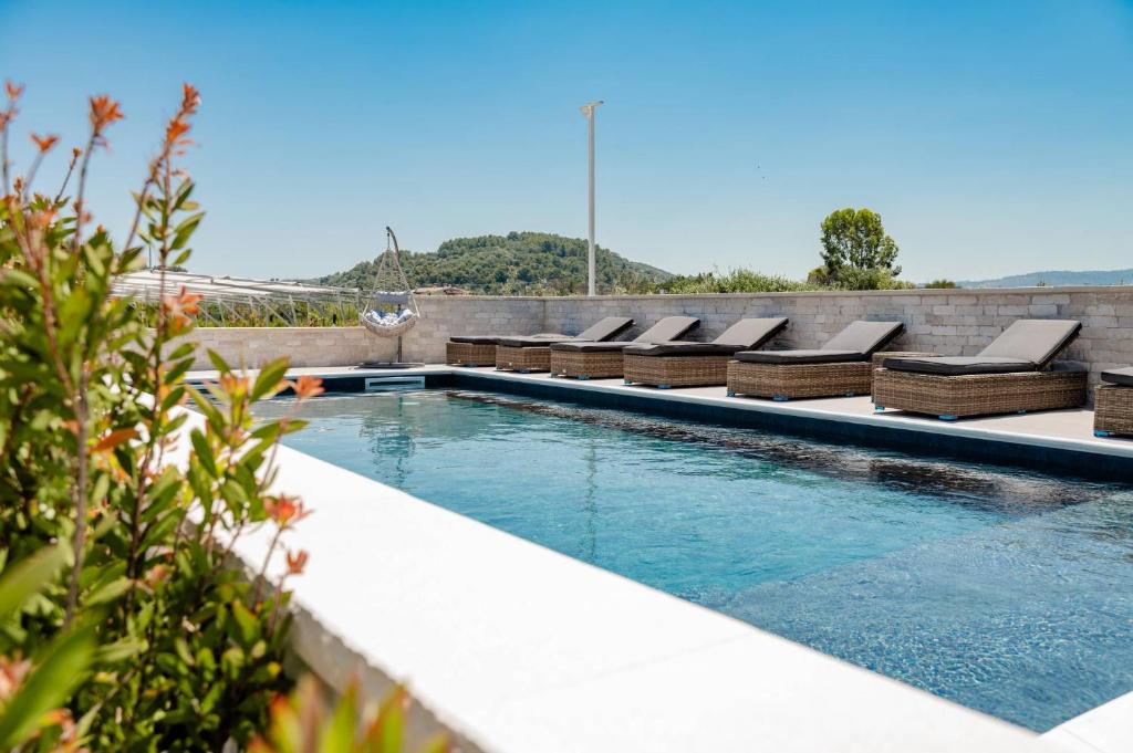 a swimming pool with lounges and chairs on a building at Aqua Sea Relais, Luxury Apartment & Pool in Vieste