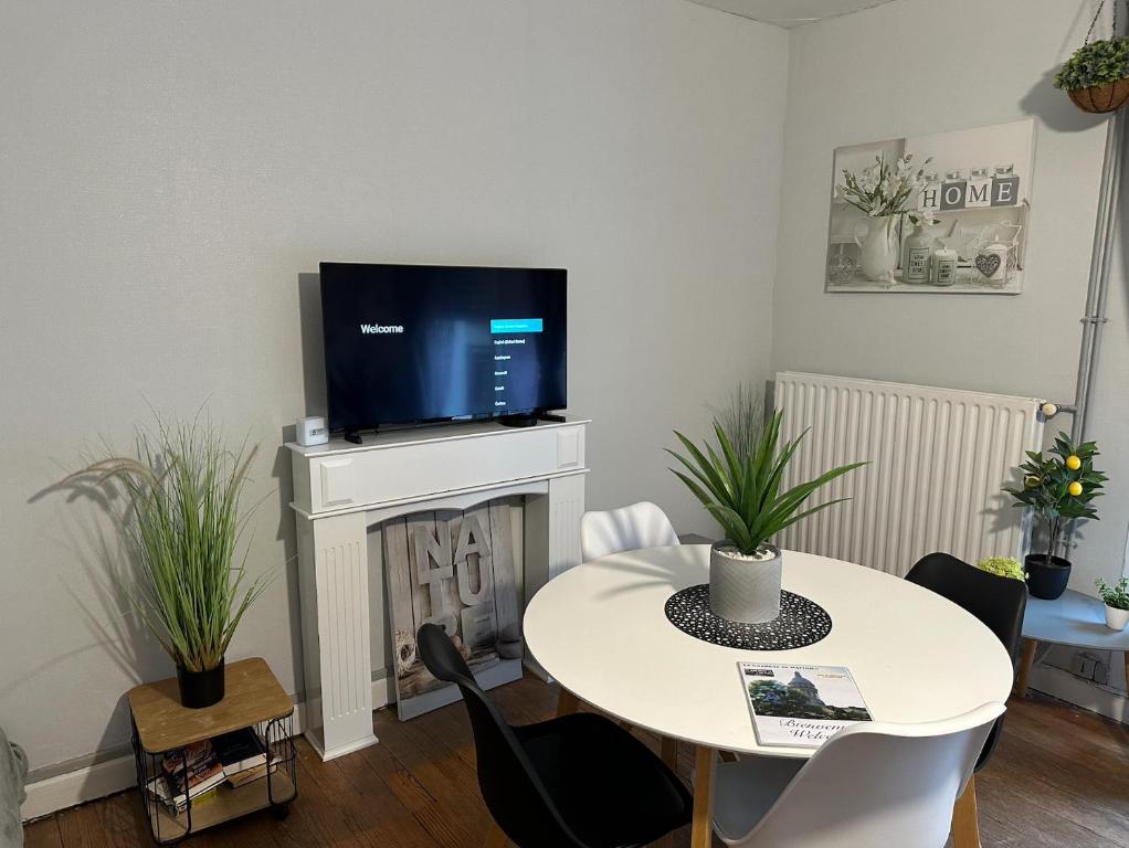 - un salon avec une table et une télévision près de la cheminée dans l'établissement appartement vivier 4 personnes tout confort, à Boulogne-sur-Mer