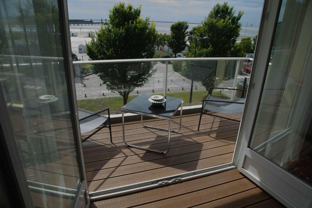 a balcony with a table and chairs on a deck at Appartement cosy vue mer face NAUSICA in Boulogne-sur-Mer