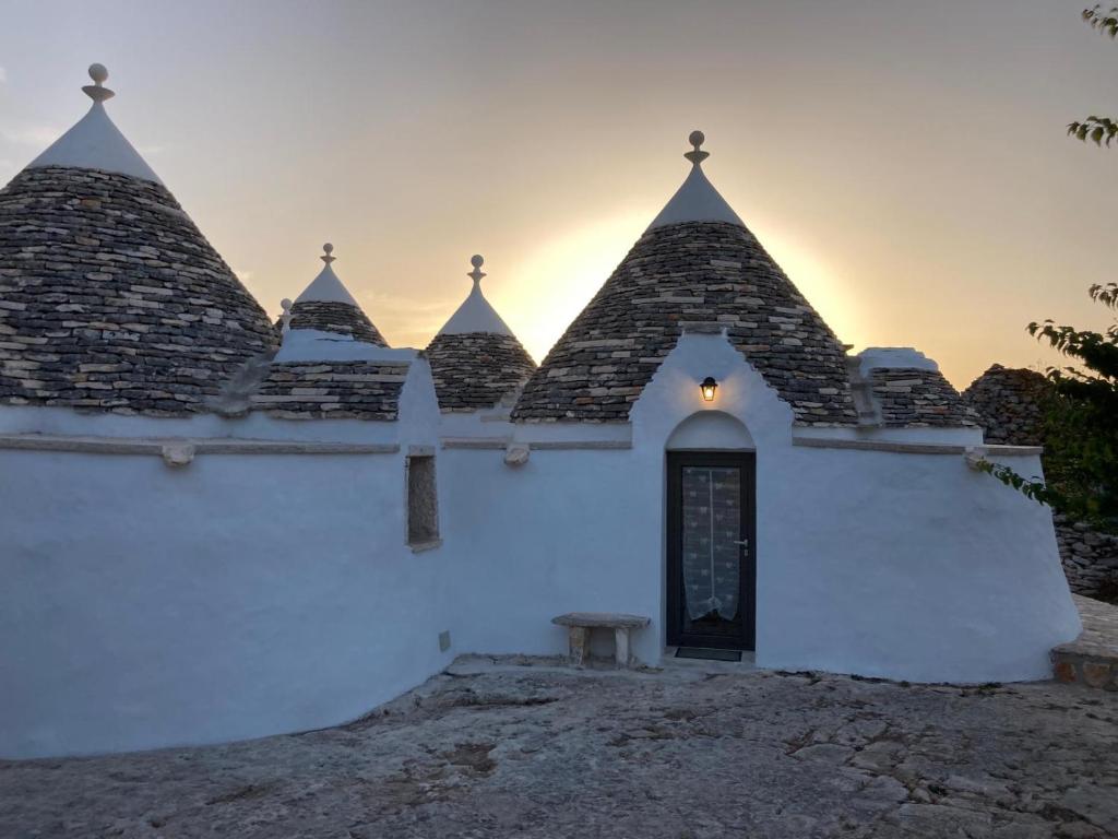 un bâtiment blanc avec un banc devant lui dans l'établissement I PapaTrulli MiniResort, à Martina Franca