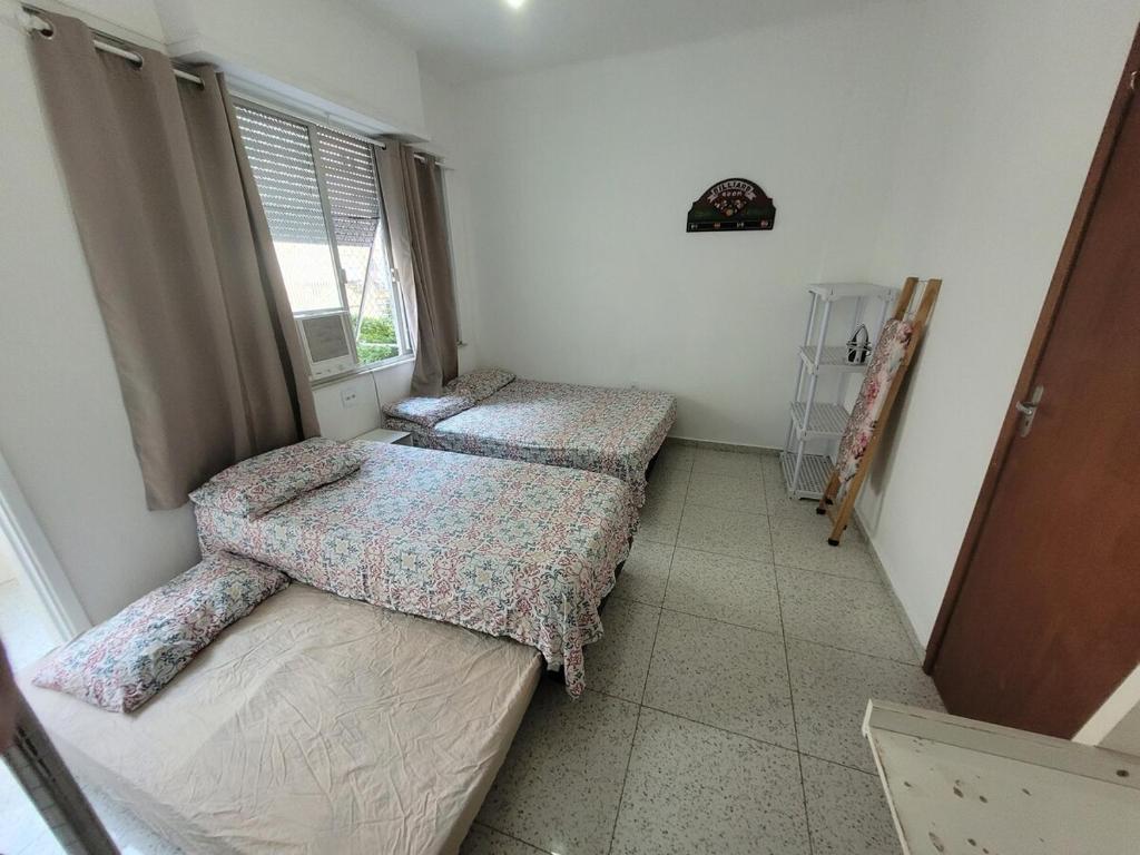 two beds in a room with a window at SUH Copacabana 01 Nice Balcony Close To Beach in Rio de Janeiro