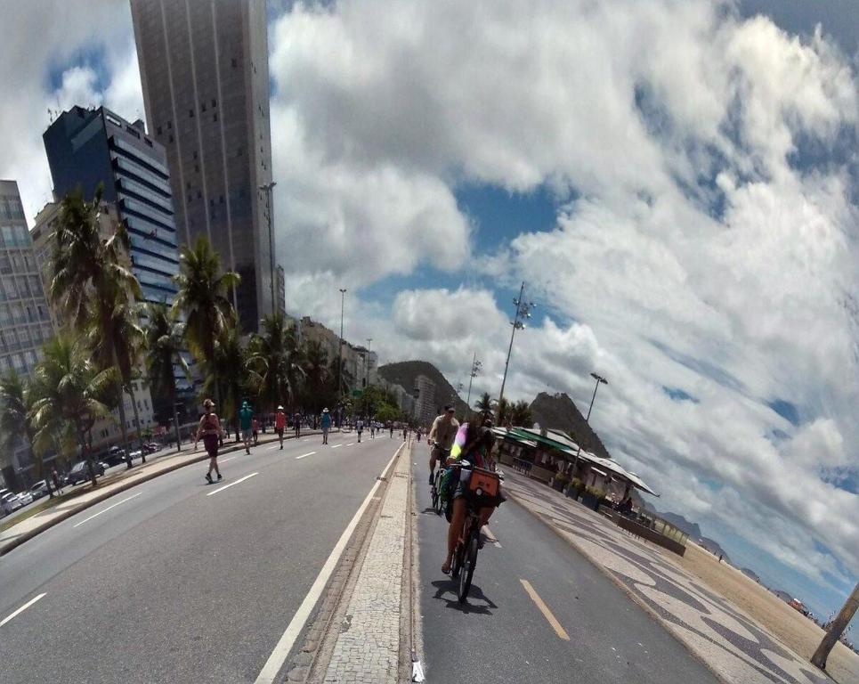 a group of people riding bikes down a city street at SUH Copacabana 01 Nice Balcony Close To Beach in Rio de Janeiro