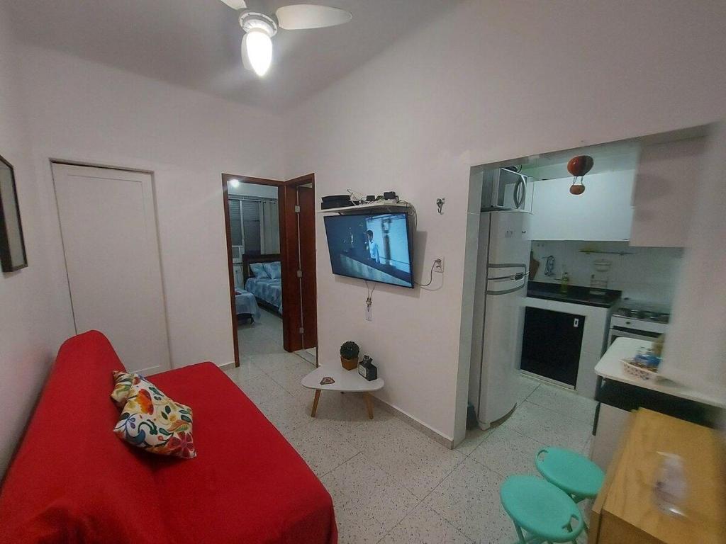 a living room with a red couch and a kitchen at SUH Copacabana 01 Nice Balcony Close To Beach in Rio de Janeiro
