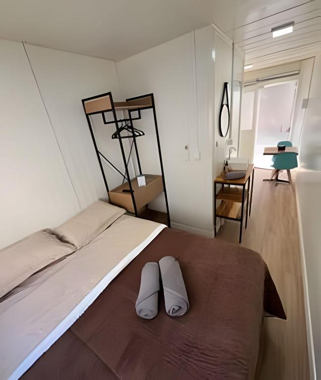 a bedroom with a bed with two white shoes on it at LN Studios in Uberlândia
